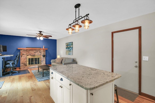 3204 Fawn Hill Ct, Urbana, IL 61802 - kitchen with light wood-type flooring, white cabinets, a ceiling fan, decorative light fixtures, and a kitchen island