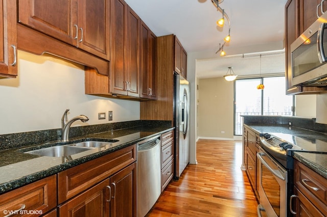70 W Huron St Unit 2202, Chicago, IL 60654 - kitchen with appliances with stainless steel finishes, light wood-style flooring, dark stone counters, decorative light fixtures, and track lighting