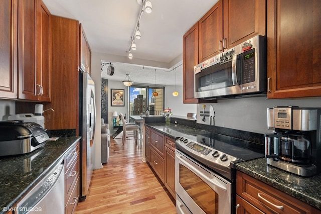 70 W Huron St Unit 2202, Chicago, IL 60654 - kitchen with stainless steel appliances, light wood finished floors, dark stone countertops, rail lighting, and brown cabinetry