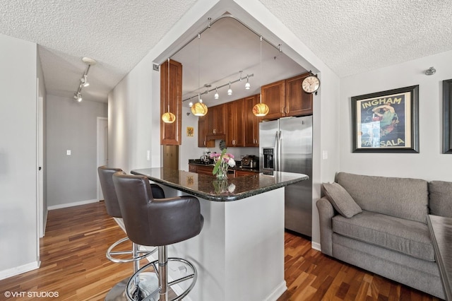 70 W Huron St Unit 2202, Chicago, IL 60654 - kitchen featuring track lighting, stainless steel refrigerator with ice dispenser, open floor plan, wood finished floors, and a breakfast bar area