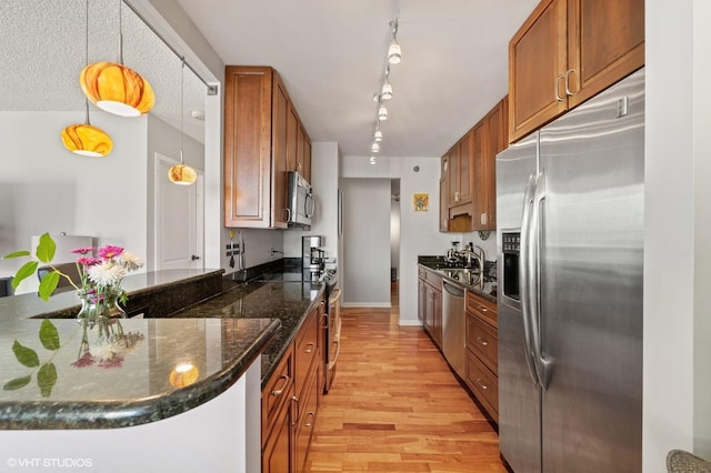 70 W Huron St Unit 2202, Chicago, IL 60654 - kitchen featuring stainless steel appliances, light wood-style floors, brown cabinets, track lighting, and dark stone counters