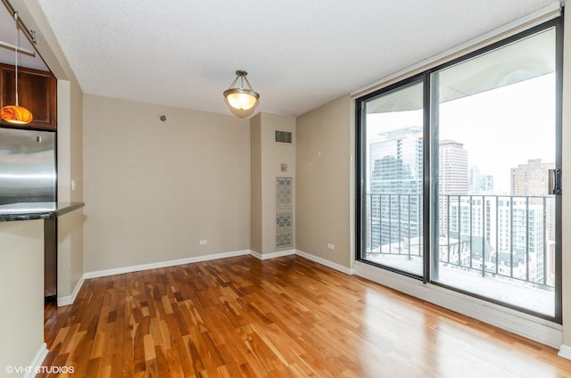 70 W Huron St Unit 2202, Chicago, IL 60654 - empty room featuring wood finished floors, a wall of windows, a textured ceiling, and a view of city