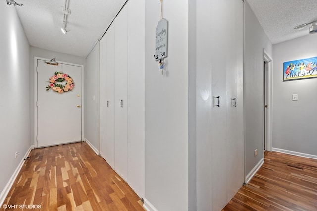 70 W Huron St Unit 2202, Chicago, IL 60654 - corridor featuring a textured ceiling, light wood finished floors, and rail lighting