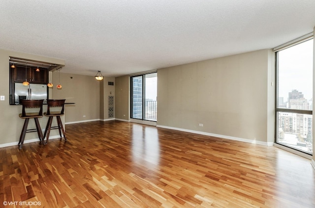 70 W Huron St Unit 2202, Chicago, IL 60654 - unfurnished living room with light wood-type flooring, expansive windows, and a textured ceiling