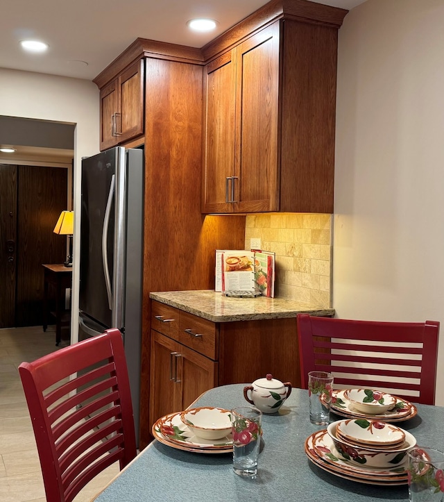 825 Pearson St Unit 3A, Des Plaines, IL 60016 - kitchen with freestanding refrigerator, brown cabinetry, backsplash, light stone countertops, and recessed lighting