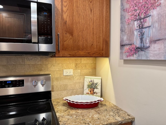 825 Pearson St Unit 3A, Des Plaines, IL 60016 - kitchen featuring stainless steel appliances, tasteful backsplash, brown cabinetry, and light countertops