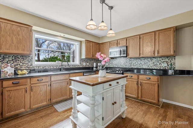 200 Ambria Dr, Mundelein, IL 60060 - kitchen featuring appliances with stainless steel finishes, backsplash, light wood-style floors, and pendant lighting