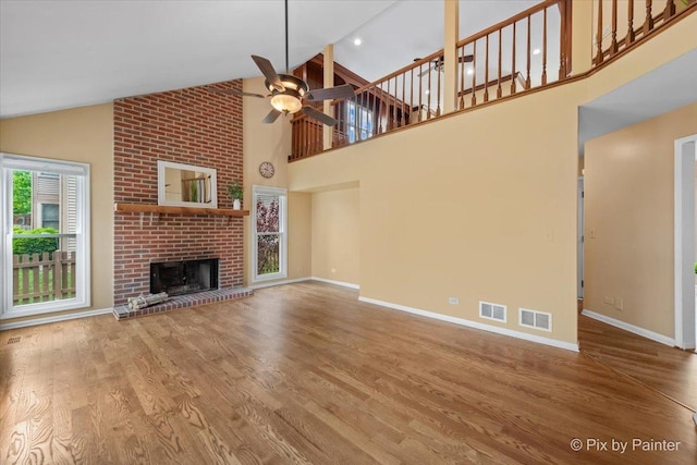 200 Ambria Dr, Mundelein, IL 60060 - unfurnished living room featuring a ceiling fan, wood finished floors, a brick fireplace, and high vaulted ceiling