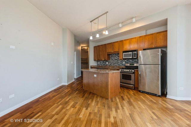 1600 S Indiana Ave Unit 508, Chicago, IL 60616 - kitchen featuring stainless steel appliances, wood finished floors, decorative backsplash, brown cabinets, and a kitchen island