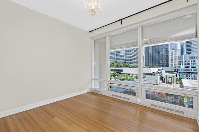 340 E Randolph St Unit 404, Chicago, IL 60601 - unfurnished room featuring a chandelier, wood finished floors, and a city view