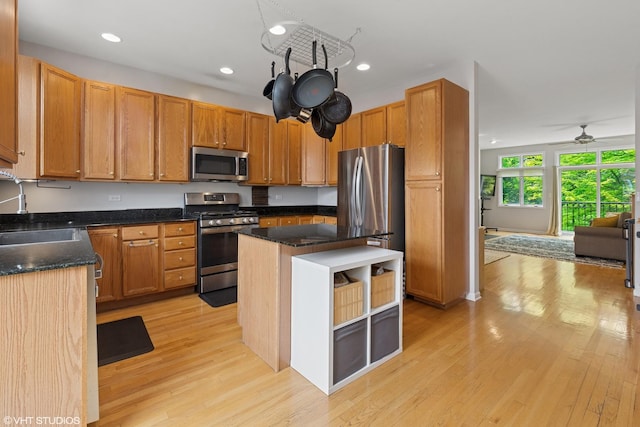 5414 S Greenwood Ave Unit 2, Chicago, IL 60615 - kitchen with appliances with stainless steel finishes, light wood-style flooring, ceiling fan, a kitchen island, and dark stone countertops