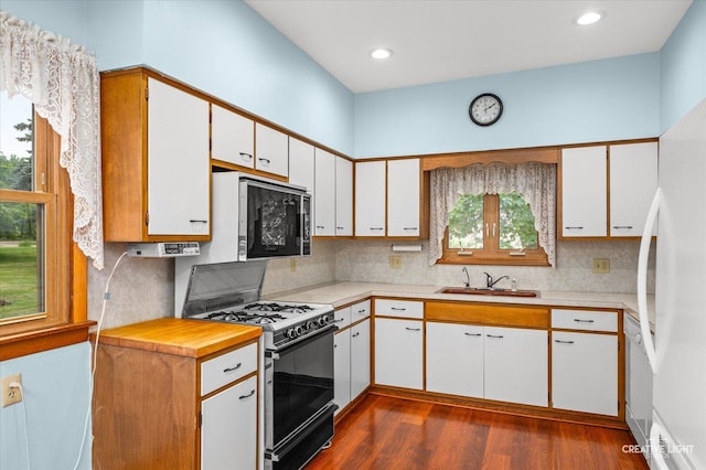 92 Maple St, Sugar Grove, IL 60554 - kitchen featuring range with gas stovetop, dark wood-style floors, freestanding refrigerator, backsplash, and white cabinets