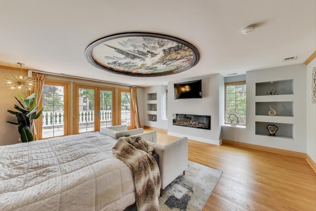 1206 Lathrop Ave, River Forest, IL 60305 - bedroom featuring access to outside, wood finished floors, a glass covered fireplace, and french doors