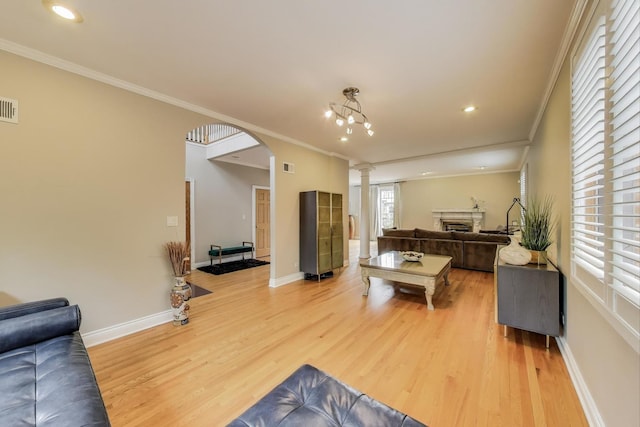 1206 Lathrop Ave, River Forest, IL 60305 - living area with arched walkways, light wood-style flooring, ornamental molding, a fireplace, and ornate columns