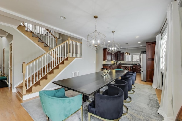1206 Lathrop Ave, River Forest, IL 60305 - dining room with stairs, light wood finished floors, a chandelier, recessed lighting, and arched walkways