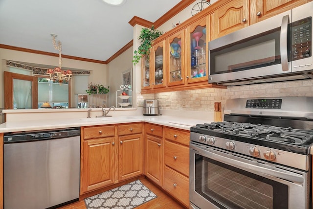 20910 W Blossom Ln, Plainfield, IL 60544 - kitchen featuring stainless steel appliances, ornamental molding, backsplash, a peninsula, and a chandelier