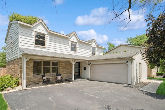 2416 Birchwood Ln, Wilmette, IL 60091 - view of front of house featuring covered porch, asphalt driveway, an attached garage, and a shingled roof