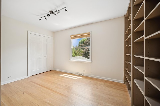 2416 Birchwood Ln, Wilmette, IL 60091 - unfurnished bedroom featuring rail lighting, wood finished floors, and a closet