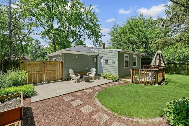 1704 Chevy Chase Dr, Champaign, IL 61821 - back of house with a wooden deck, a patio area, a fenced backyard, an outdoor fire pit, and a chimney