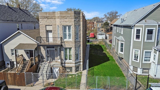 5522 S Wells St, Chicago, IL 60621 - view of front of home featuring a fenced backyard, stone siding, a residential view, and a balcony