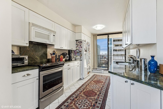 1410 N State Pkwy Unit 18B, Chicago, IL 60610 - kitchen featuring white appliances, decorative backsplash, white cabinets, and expansive windows