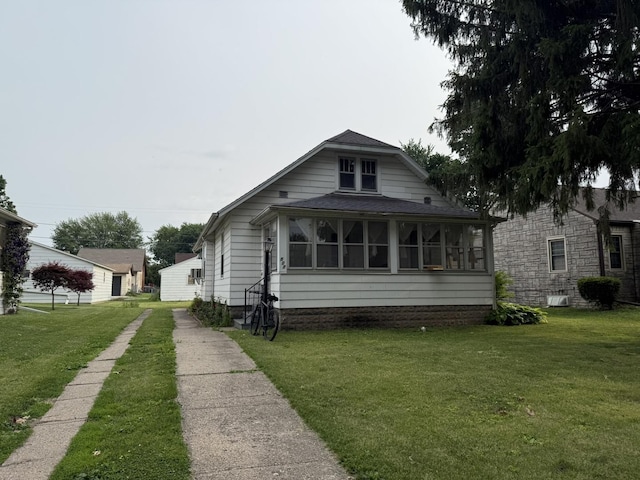507 W 12th St, Sterling, IL 61081 - bungalow with a front lawn, a shingled roof, and driveway