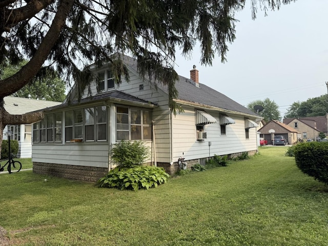 507 W 12th St, Sterling, IL 61081 - view of home's exterior with a sunroom, a chimney, a yard, a shingled roof, and cooling unit