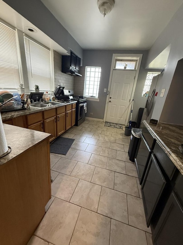 7544 S Sangamon St, Chicago, IL 60620 - kitchen with gas range oven, light tile patterned floors, brown cabinetry, and tasteful backsplash