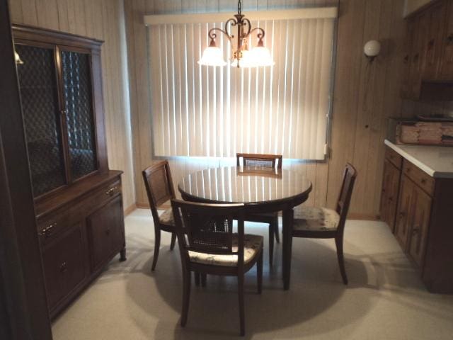 7341 W 56th Pl, Summit, IL 60501 - dining room featuring a chandelier, wooden walls, and plenty of natural light
