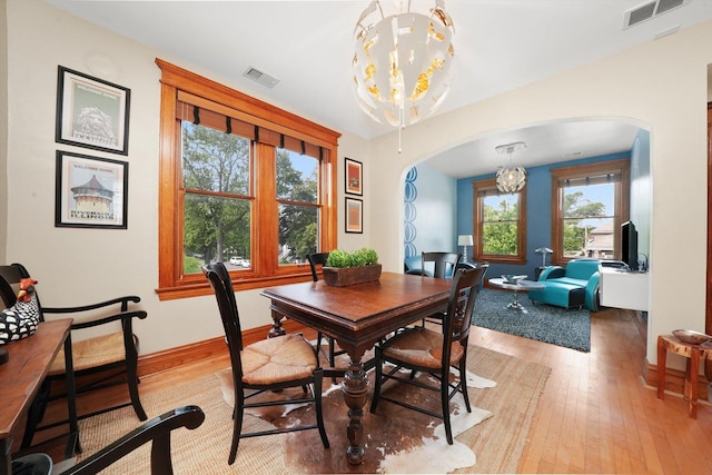 2347 Clarence Ave, Berwyn, IL 60402 - dining space with arched walkways, a chandelier, and light wood-type flooring