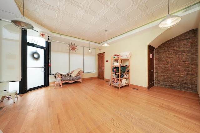 2347 Clarence Ave, Berwyn, IL 60402 - living area featuring light wood-style flooring, healthy amount of natural light, an ornate ceiling, brick wall, and arched walkways