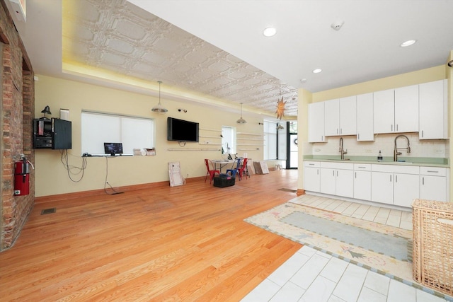 2347 Clarence Ave, Berwyn, IL 60402 - kitchen with light wood-type flooring, a tray ceiling, white cabinets, light countertops, and an ornate ceiling