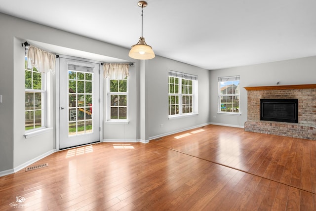 2008 Crosswind Dr, Plainfield, IL 60586 - unfurnished living room with hardwood / wood-style floors and a brick fireplace