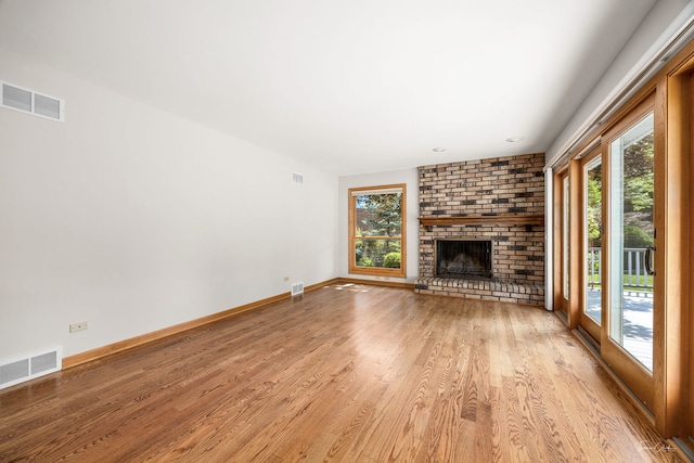 1447 Hillcrest Rd, Downers Grove, IL 60516 - unfurnished living room featuring light wood finished floors and a brick fireplace