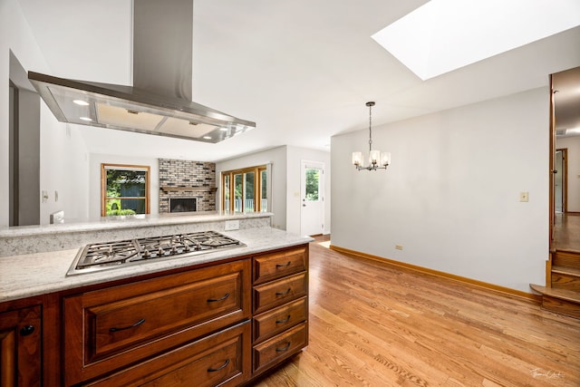 1447 Hillcrest Rd, Downers Grove, IL 60516 - kitchen featuring wall chimney exhaust hood, stainless steel gas stovetop, a skylight, a chandelier, and light countertops