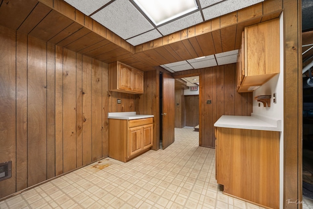 1447 Hillcrest Rd, Downers Grove, IL 60516 - kitchen featuring wood walls, light countertops, light floors, and brown cabinets