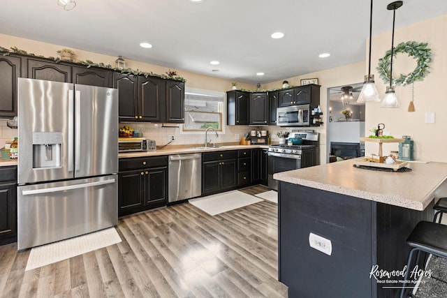 840 Peony Ln, Bourbonnais, IL 60914 - kitchen featuring appliances with stainless steel finishes, light countertops, light wood-style flooring, decorative backsplash, and recessed lighting