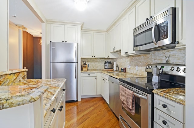 405 N Wabash Ave Unit 2211, Chicago, IL 60611 - kitchen with appliances with stainless steel finishes, tasteful backsplash, light wood finished floors, light stone countertops, and white cabinets