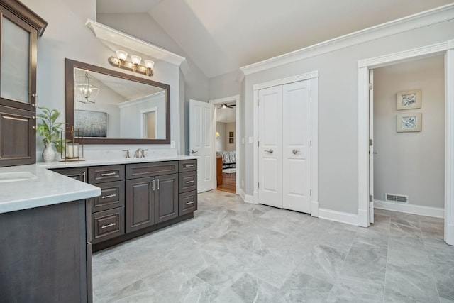 38W385 Stevens Glen Rd, Saint Charles, IL 60175 - ensuite bathroom featuring vaulted ceiling, two vanities, marble look tile flooring, a chandelier, and ornamental molding