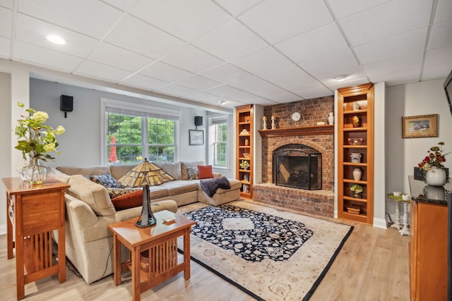 38W385 Stevens Glen Rd, Saint Charles, IL 60175 - living room featuring light wood-type flooring, a brick fireplace, a paneled ceiling, and built in features