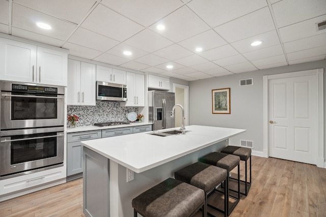 38W385 Stevens Glen Rd, Saint Charles, IL 60175 - kitchen featuring stainless steel appliances, a kitchen breakfast bar, backsplash, light countertops, and light wood finished floors