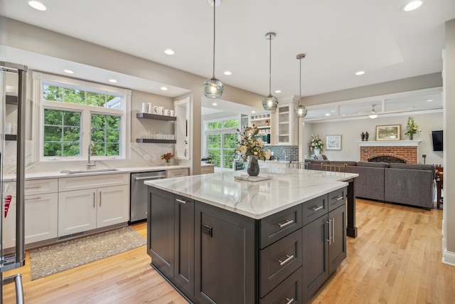 38W385 Stevens Glen Rd, Saint Charles, IL 60175 - kitchen featuring stainless steel dishwasher, white cabinetry, light wood finished floors, a brick fireplace, and recessed lighting