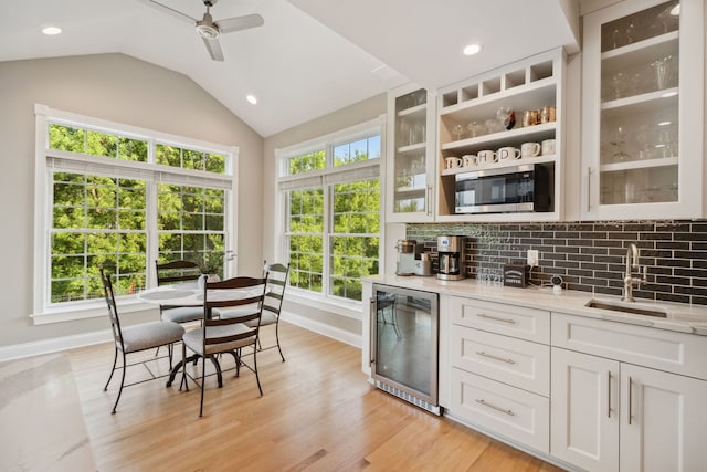 38W385 Stevens Glen Rd, Saint Charles, IL 60175 - indoor bar with stainless steel microwave, beverage cooler, a ceiling fan, decorative backsplash, and vaulted ceiling