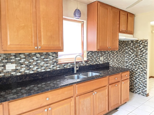 3909 W 71st St, Chicago, IL 60629 - kitchen with under cabinet range hood, light tile patterned floors, backsplash, and dark stone counters