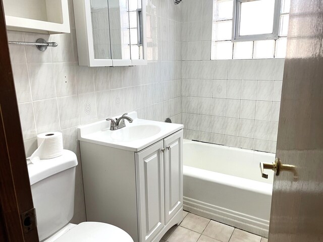 3909 W 71st St, Chicago, IL 60629 - bathroom with tile patterned floors, vanity, tile walls, and tub / shower combination