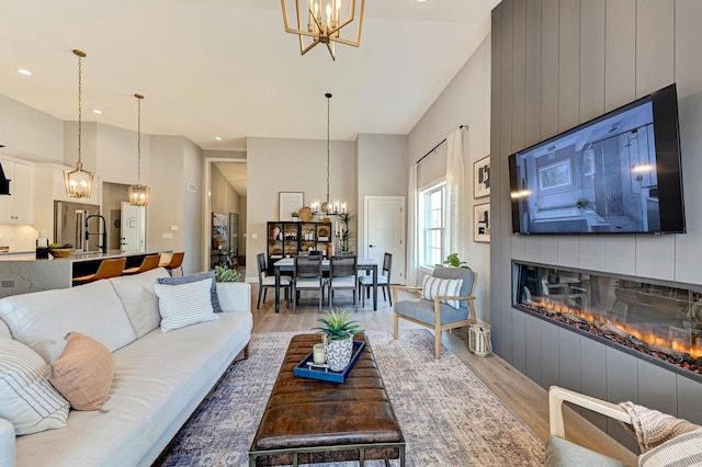 12830 Marble St Unit 25A, Lemont, IL 60439 - living area featuring a chandelier, light wood-style flooring, a fireplace, a towering ceiling, and recessed lighting