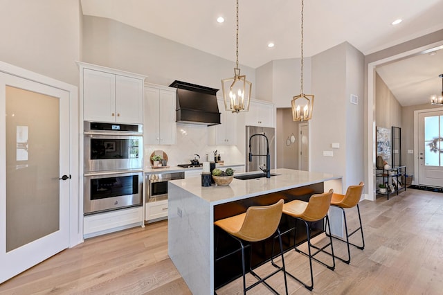 12830 Marble St Unit 25A, Lemont, IL 60439 - kitchen with stainless steel appliances, a chandelier, custom exhaust hood, light wood-type flooring, and white cabinets
