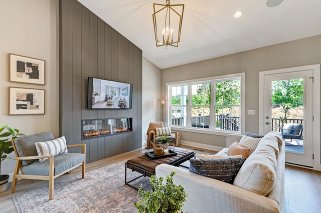 12830 Marble St Unit 25A, Lemont, IL 60439 - living area featuring a large fireplace, light wood-style flooring, a chandelier, and high vaulted ceiling