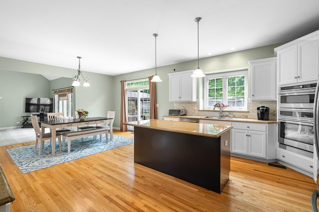 11646 Liberty Ln, Plainfield, IL 60585 - kitchen featuring a center island, light wood-type flooring, white cabinetry, tasteful backsplash, and recessed lighting