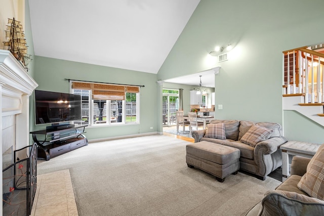 11646 Liberty Ln, Plainfield, IL 60585 - carpeted living area with high vaulted ceiling, stairway, a fireplace, and a chandelier
